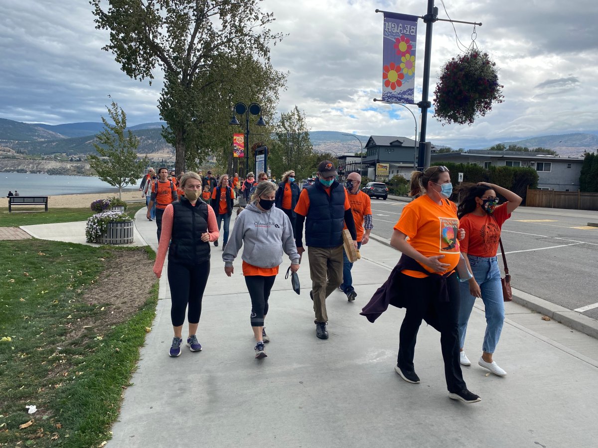 Hundreds of people walk along Lakeshore Drive in Penticton, B.C., on Thursday, Sept. 30, 2021. Communities across Canada are marking the country's first National Day for Truth and Reconciliation, honouring Indigenous survivors and children who disappeared from the residential school system.
