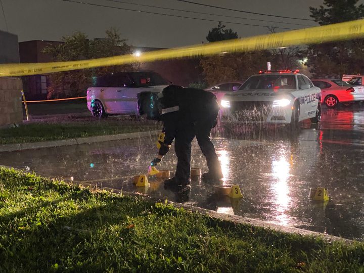 A police officer places evidence markers at the scene of a fatal shooting in Mississauga on Wednesday.