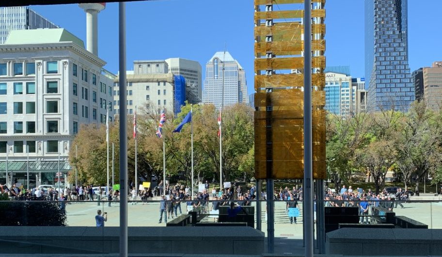 Dozens of people stand in formation in front of Calgary city hall on Sep. 7, 2021, to protest a vaccine mandate for city employees.