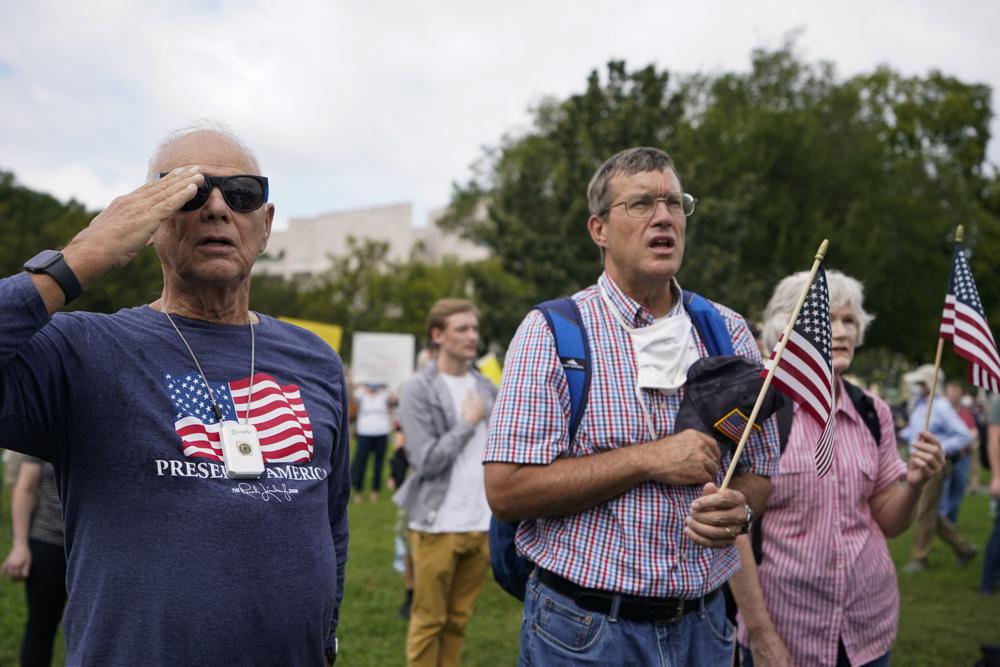 People stand as the national anthem plays during a rally near the U.S. Capitol in Washington, Saturday, Sept. 18, 2021. The rally was planned by allies of former President Donald Trump and aimed at supporting the so-called “political prisoners” of the Jan. 6 insurrection at the U.S. Capitol. (AP Photo/Brynn Anderson)
