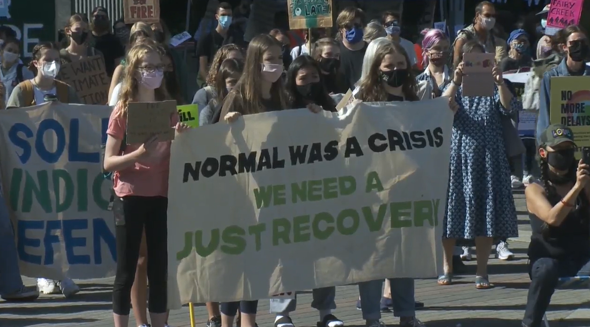 Youth hold a sign calling for a green COVID-19 recovery at a protest in Vancouver on Friday. 