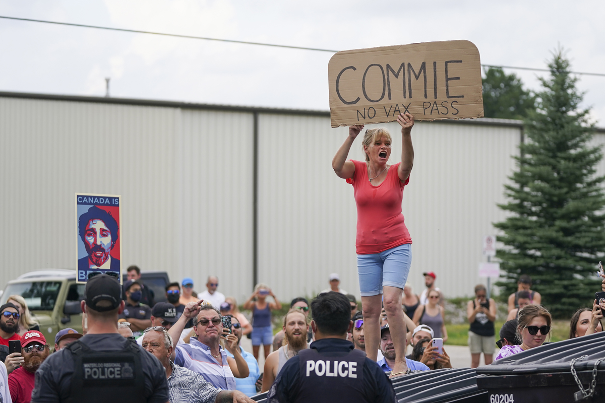 Protesters scream as police secure the property as Liberal leader Justin Trudeau announces green incentives towards climate change at a campaign stop during the Canadian federal election campaign in Cambridge, Ont., on Sunday, August 29, 2021. 