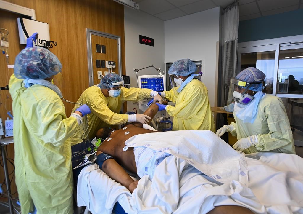 Health-care workers turn a COVID-19 patient in the ICU who is intubated and on a ventilator from his back to his stomach at the Humber River Hospital during the COVID-19 pandemic in Toronto on Wednesday, December 9, 2020. 