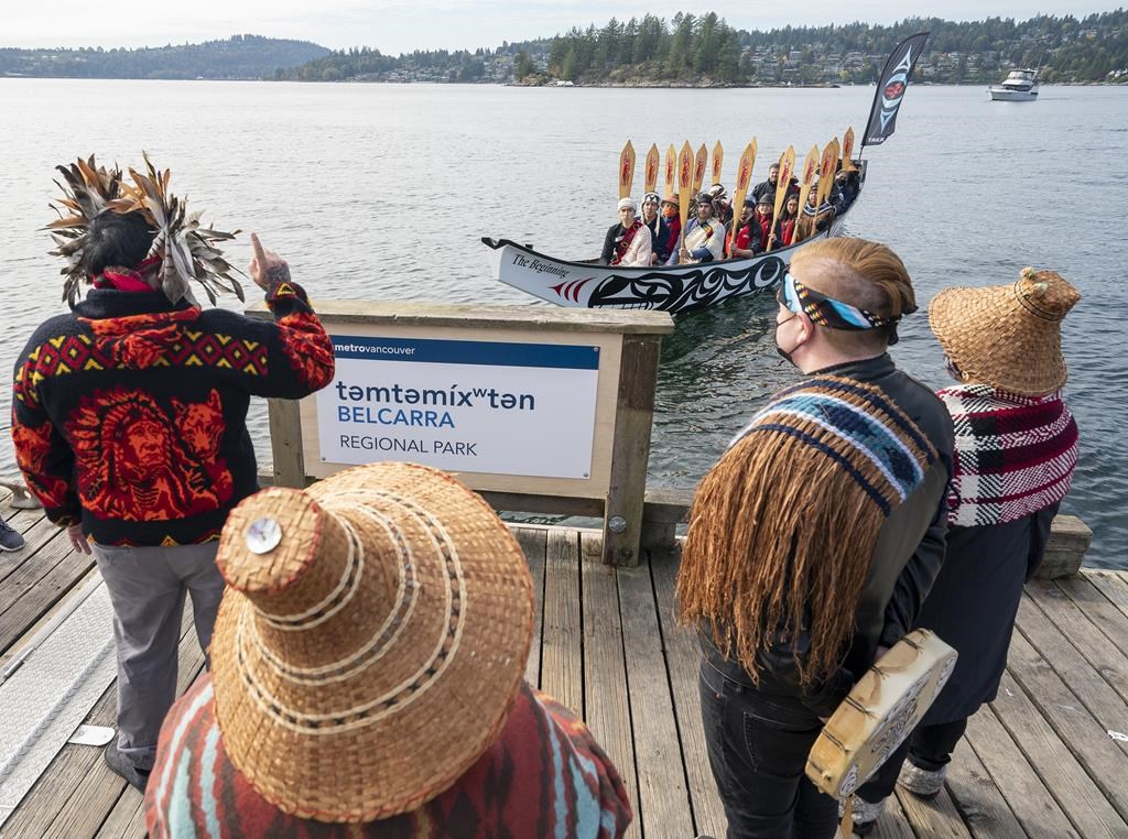Paddlers from the Tsleil-Waututh Nation are greeted as they arrive by traditional canoe to take part in a park renaming ceremony at Belcarra Regional Park in Belcarra, B.C., Friday, Oct. 9, 2021. Belcarra Regional Park, near Port Moody, B.C., will have an Indigenous name of temtemíxwten, which local First Nations say translates to "biggest place for all the people." THE CANADIAN PRESS/Jonathan Hayward.