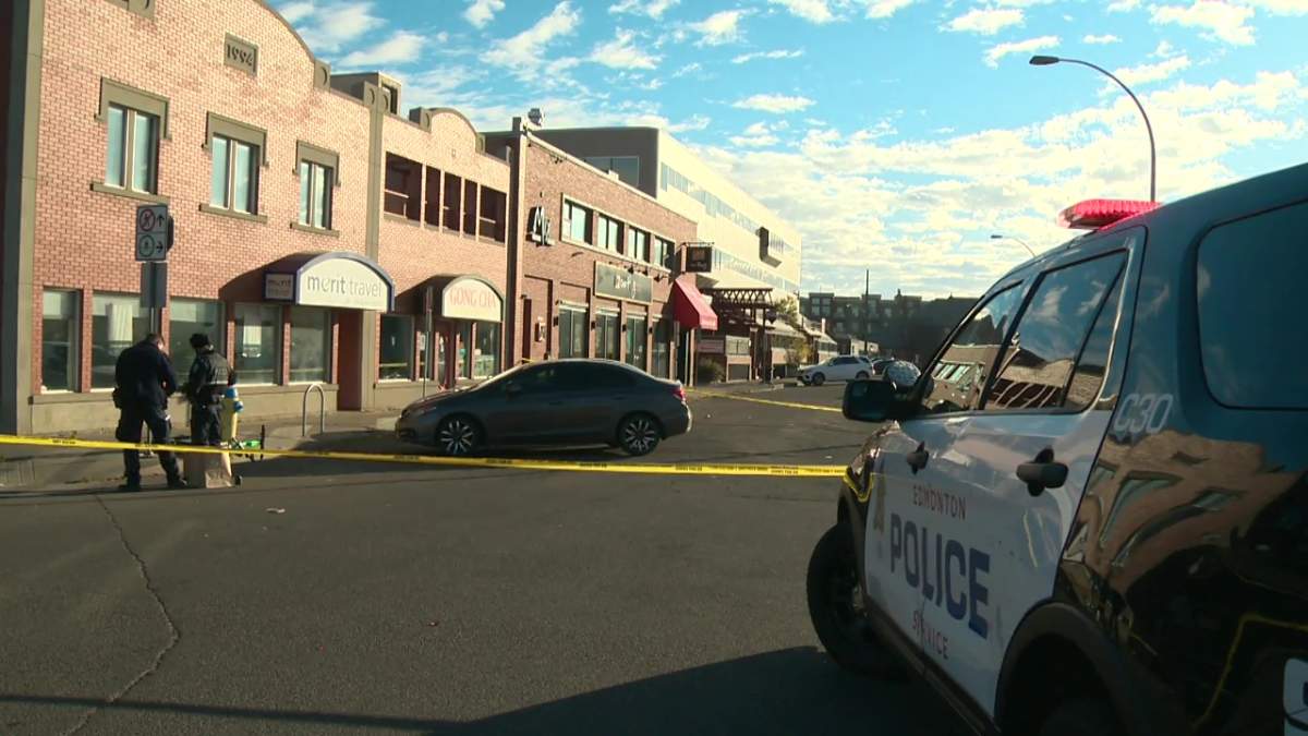 Edmonton police examine the corner of 81 avenue and 104 street after reports of a shooting on Oct. 3, 2021.