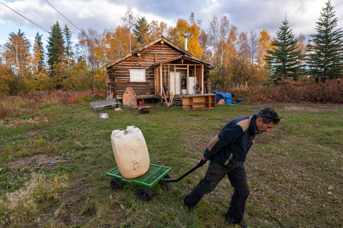 Ben Stevens hauls fuel to his river boat before leaving for the Stevens’ family hunting camp on the Yukon River on Tuesday, Sept. 14, 2021, in Stevens Village, Alaska. Two salmon species have all but disappeared from Alaska’s Yukon River this year, prompting the state to shut down fishing in an effort to save them.