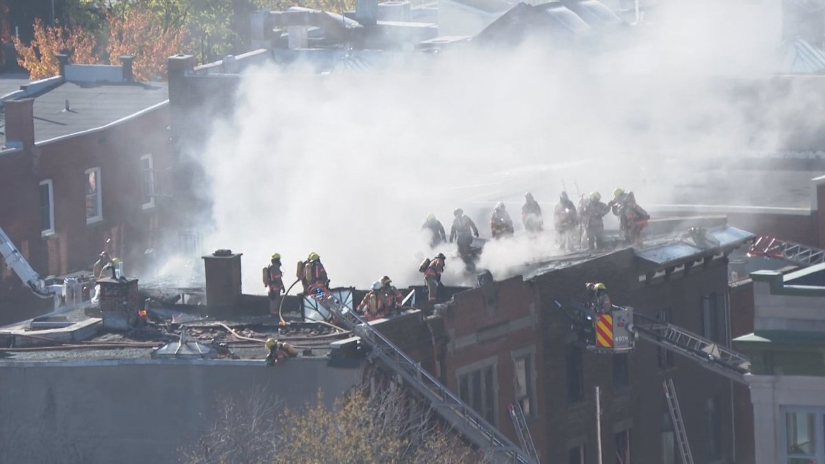 Firefighters can be seen on the roof of a building in downtown Montreal on Friday, Oct. 29, 2021.