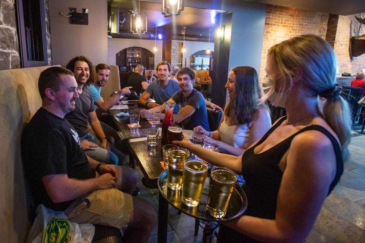 Waitress Kirsten Craig wears a mask to protect her from the COVID-19 virus while serving customers at the Blu Martini restaurant.
  THE CANADIAN PRESS IMAGES/Lars Hagberg.