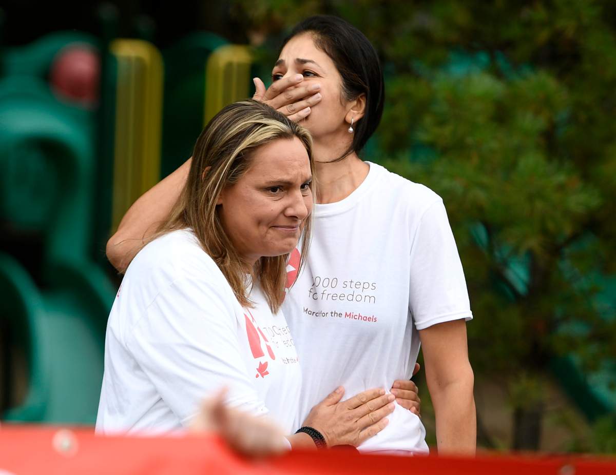 Vina Nadjibulla, wife of Michael Kovrig, is embraced by Ariana Botha, Kovrig’s sister, after speaking before the March for the Michaels, marking the 1,000 days since Canadians Michael Kovrig and Michael Spavor were detained in China, in Ottawa, on Sunday, Sept. 5, 2021. THE CANADIAN PRESS/Justin Tang