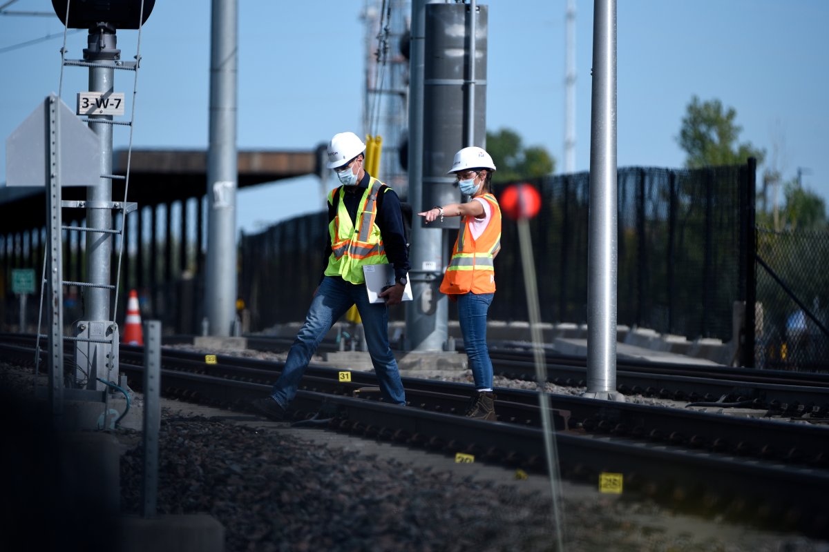 Workers wearing a hard hats from train manufacturer Alstom work among evidence markers laid on the tracks  Monday, Sept. 20, 2021 after an OC Transpo O-Train derailed west of Tremblay LRT Station on Sunday in Ottawa. 
