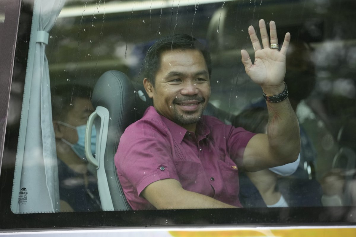 Retired Filipino boxing hero and senator Manny Pacquiao waves from his vehicle before filing his certificate of candidacy for next year's presidential elections at the Commission on Elections on Friday, Oct. 1, 2021 in Manila, Philippines. Friday marks the first day of a week-long period when politicians can file their certificates of candidacy for the May 9, 2022 national elections where Filipinos will get to vote for their next president, vice president, and other national and local officials.(AP Photo/Aaron Favila).