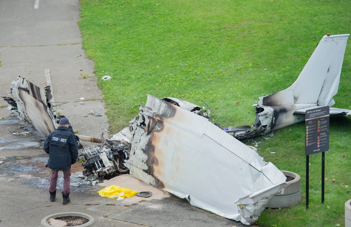 A member of the Transportation Safety Board (TSB) inspects the wreckage of a plane at a crash site in Montreal, Sunday, Oct. 3, 2021. 
