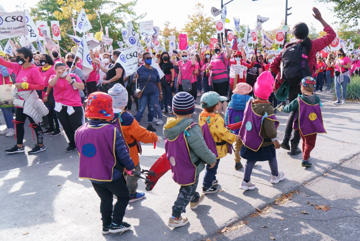 Children from a daycare walk past a demonstration of daycare workers on the first day of rotating strikes in Montreal on Tuesday, October 12, 2021. 