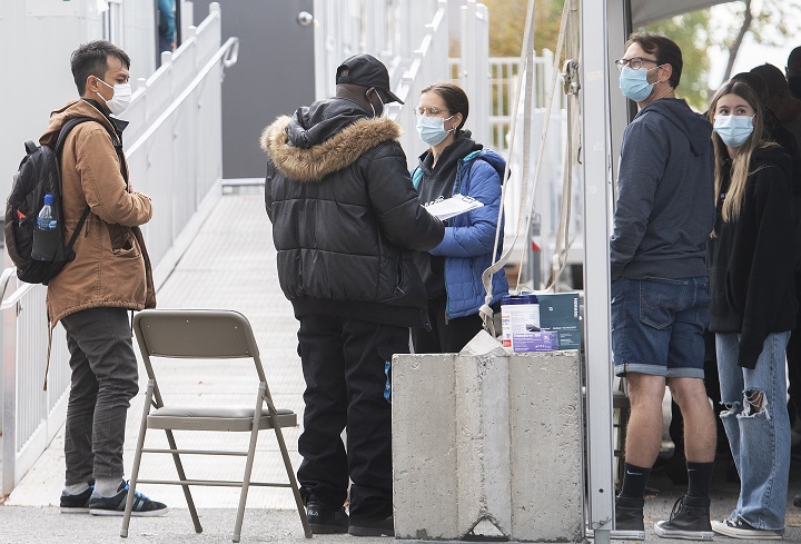 People are shown at a COVID-19 testing clinic in Montreal, Sunday, Oct. 17, 2021.