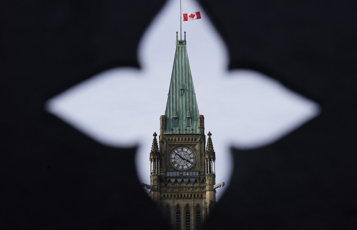 The Canadian flag flies at half mast over the Peace tower and parliament buildings Friday, Oct. 22, 2021.