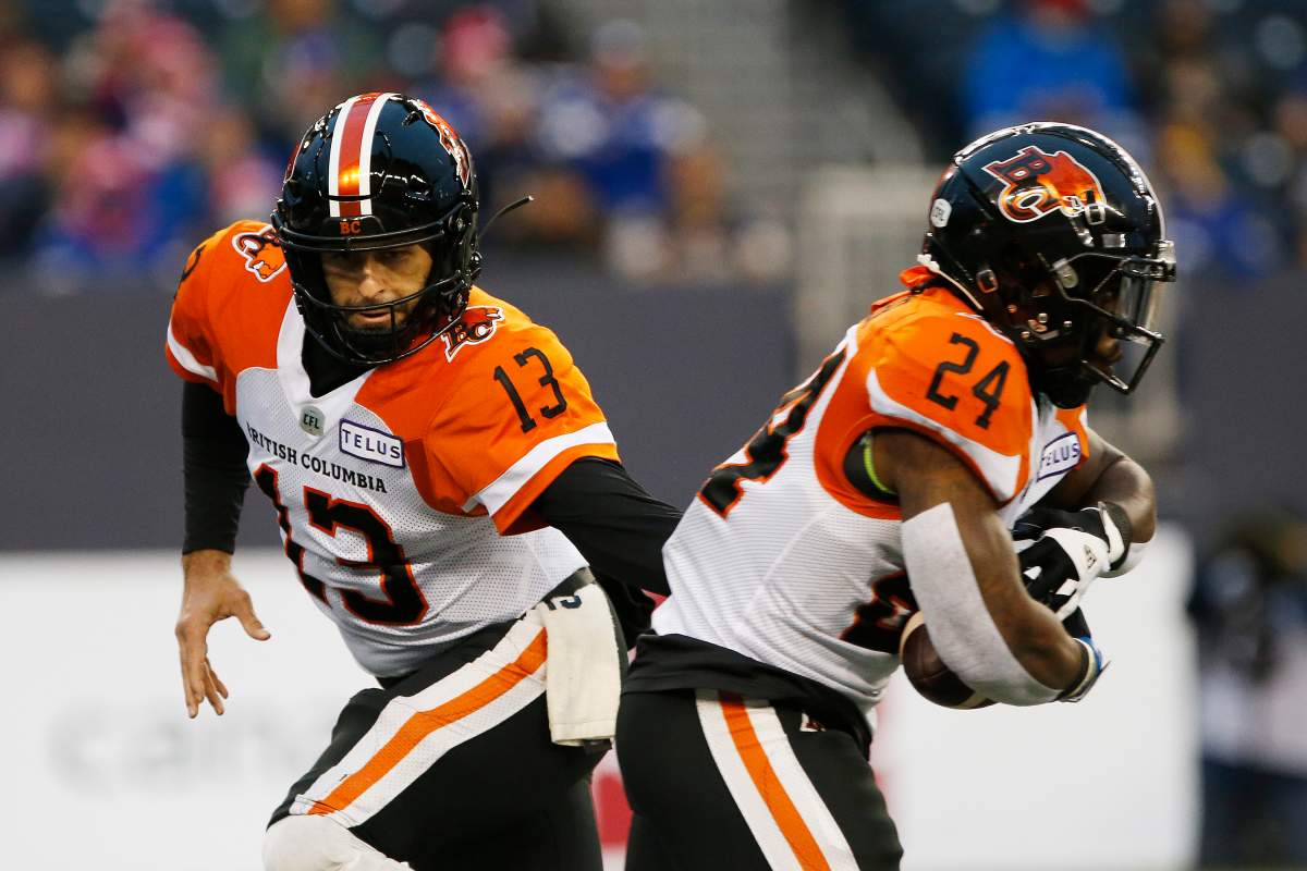 B.C. Lions quarterback Mike Reilly (13) hands off to James Butler (24) against the Winnipeg Blue Bombers during the first half of CFL action in Winnipeg Saturday, October 23, 2021.