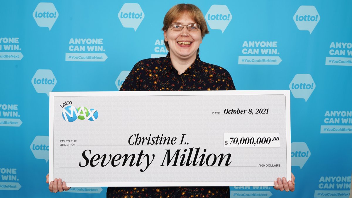 Christine Lauzon shows off her winnings in the largest-ever lottery prize awarded in B.C.