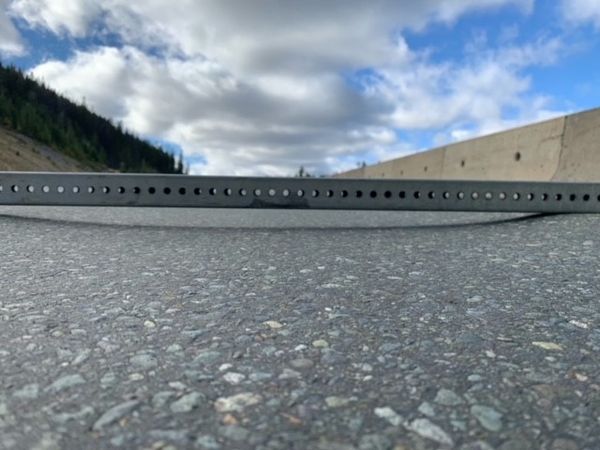 A straight edge showing the depth of a rut along the Coquihalla Highway.