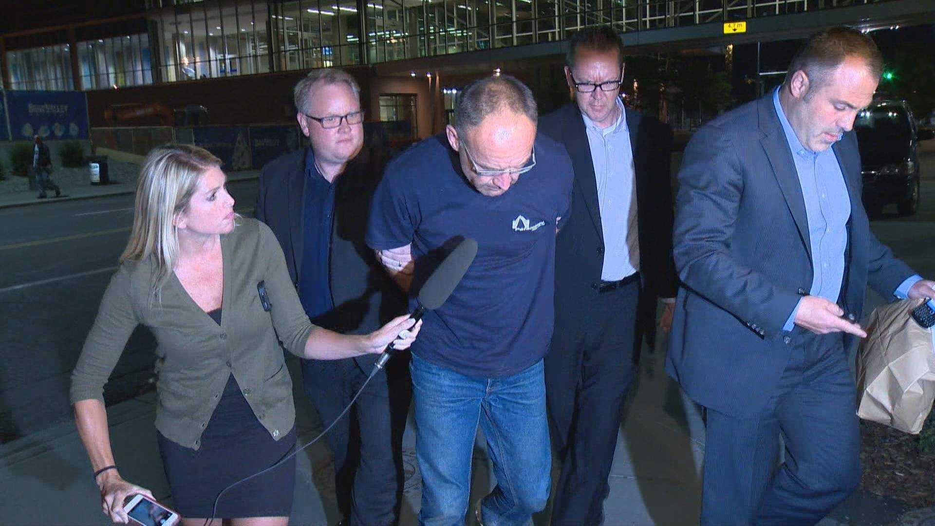 Douglas Garland is escorted into a Calgary police station in connection with the disappearance of Nathan O'Brien and his grandparents in Calgary, Alta.