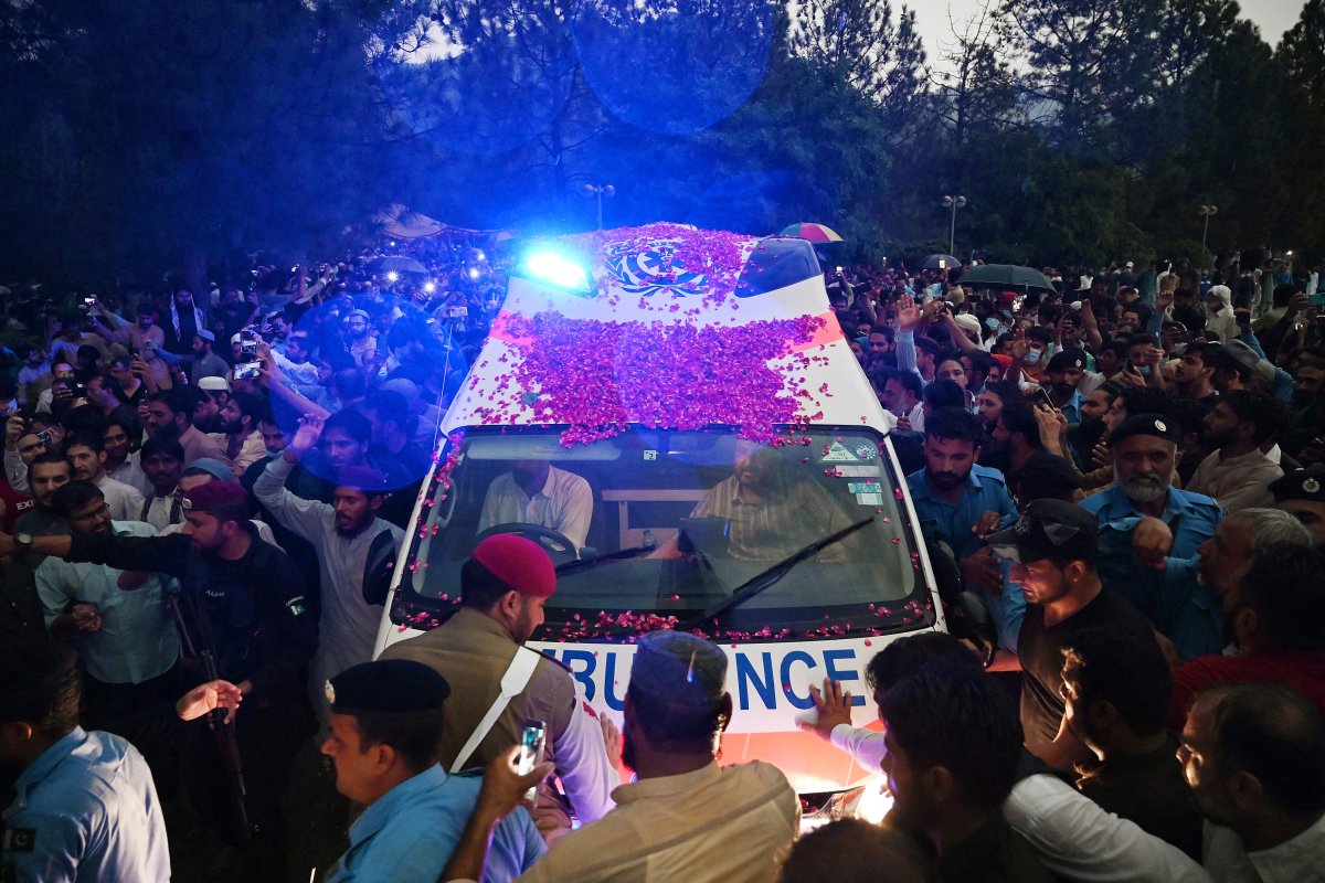 Supporters and officials gather around an ambulance carrying the coffin of the late Pakistan’s nuclear scientist Abdul Qadeer Khan for his funeral outside the Faisal Mosque following his death in Islamabad on Oct. 10, 2021.