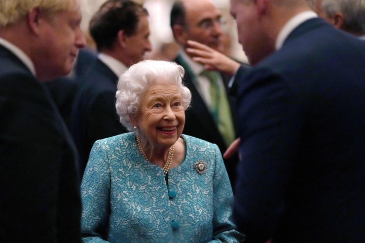 Britain's Queen Elizabeth II (C) and Britain's Prime Minister Boris Johnson (L) greet guests during a reception to mark the Global Investment Summit, at Windsor Castle in Windsor, west of London on Oct. 19, 2021.