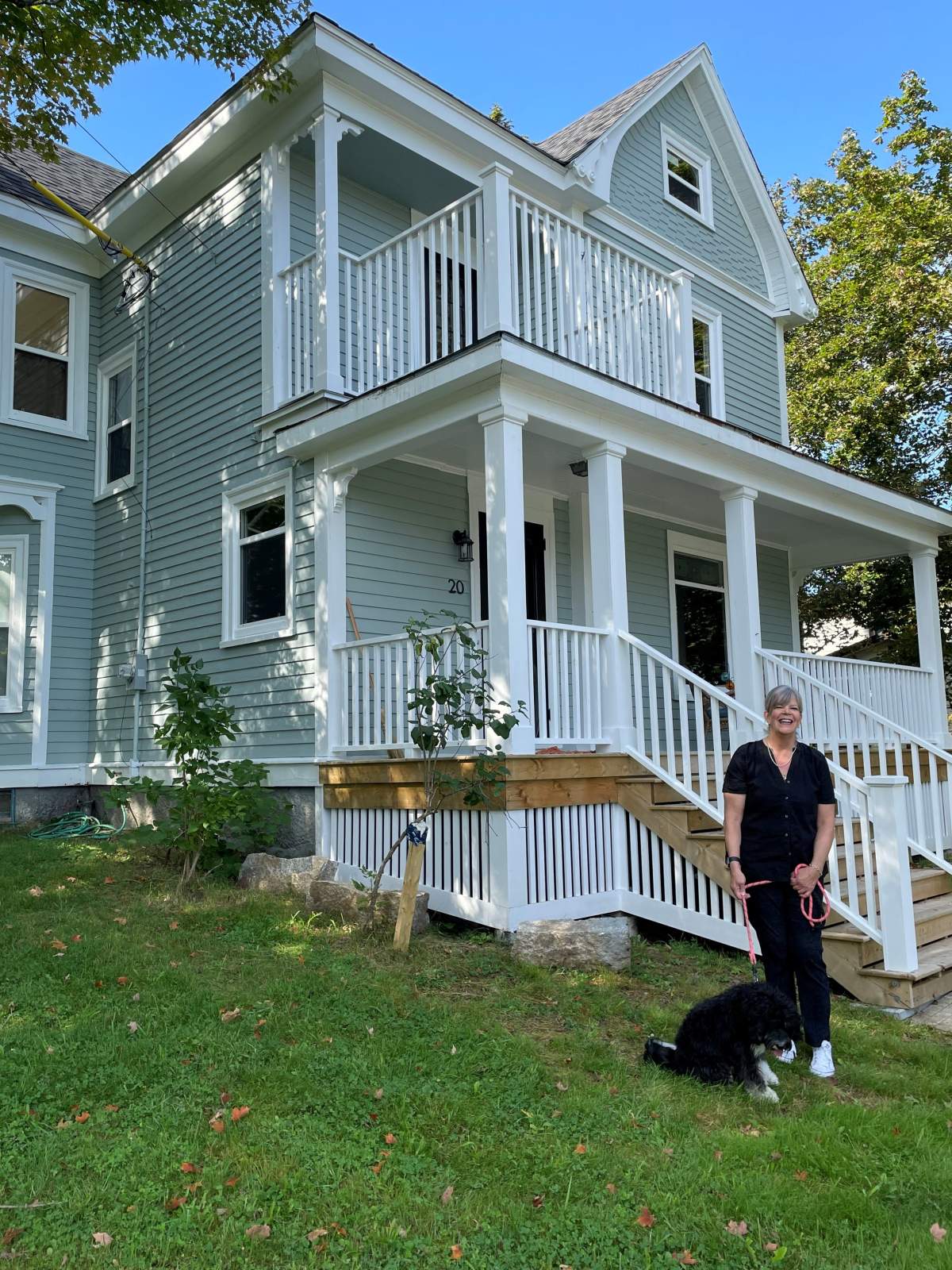 Former Toronto resident Karen Wright with her pandemic puppy in front of her new home, purchased sight unseen.