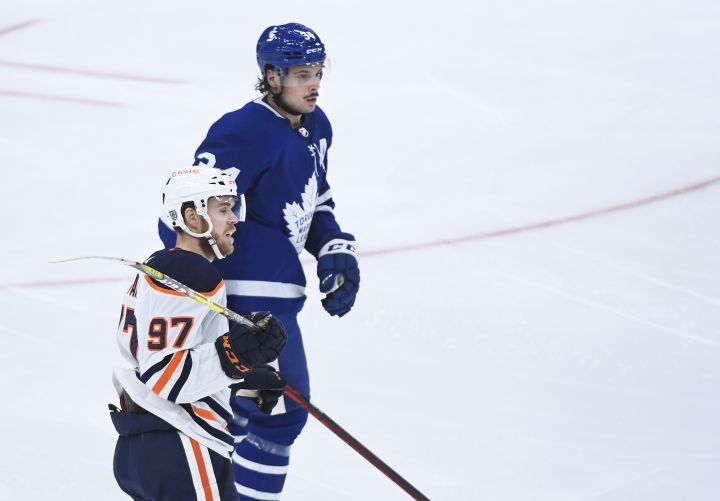 Edmonton Oilers centre Connor McDavid (97) keeps close to Toronto Maple Leafs centre Auston Matthews (34) during second period NHL hockey action in Toronto on Wednesday, January 20, 2021.