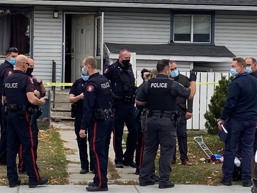 Calgary police officers at a home where an 18-month-old child was found dead on Tuesday, Oct. 5, 2021.