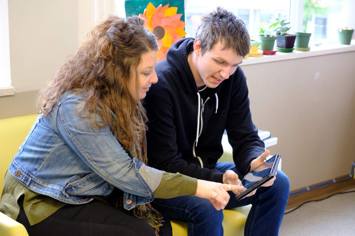 Taylor Bundun, a young adult peer support worker, speaks with staff at Coast Mental Health in Vancouver, B.C. 