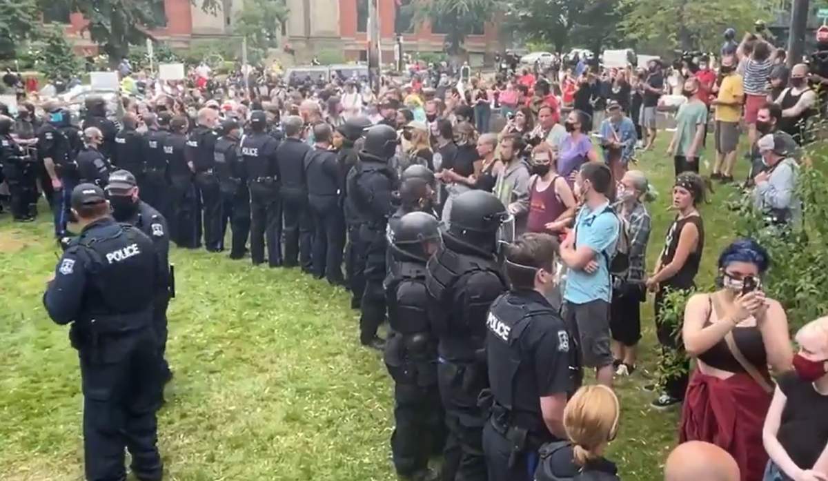 Halifax Regional Police officers and protesters face off during a protest over the removal of crisis shelters in Halifax on Aug. 18, 2021.