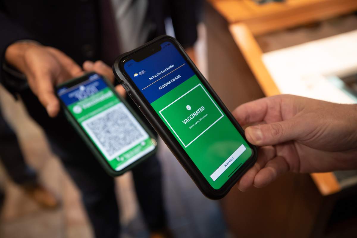Ravi Kahlon, B.C. Minister of Jobs, Economic Recovery and Innovation, has his provincial COVID-19 vaccine card scanned by White Spot restaurant general manager Bill Warwick, before having breakfast in Delta, B.C., on Wednesday, September 15, 2021. 