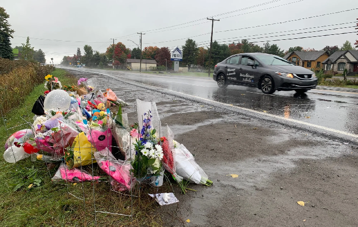 Flowers lay by the side of route 335, where a driver struck and killed a teenage boy on Wednesday and did not stop to help.