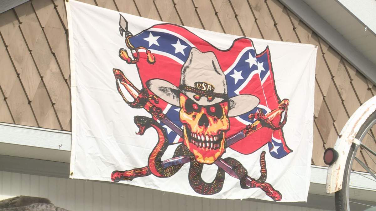 A Confederate flag with a skull face wearing a cowboy hat that says “CSA,” or the Confederate States of America, hangs above the Kelowna home.