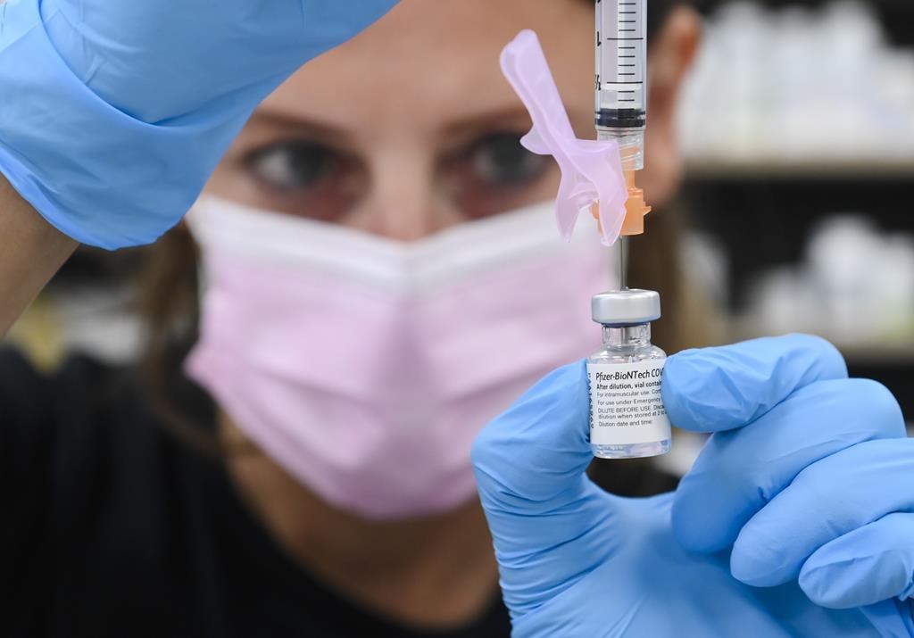 A pharmacist and draws up a dose of the Pfizer-BioNTech COVID-19 vaccine, in Toronto, Friday, June 18, 2021.