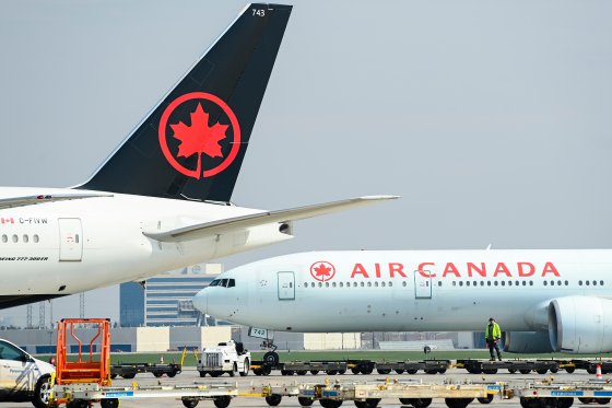 Air Canada planes sit at an airport.
