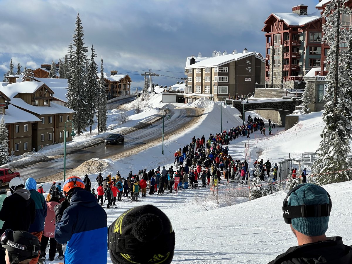 A long line of skiers and snowboarders wait to get on the bullet express chairlift on opening day at the Big White Ski Resort on Friday.