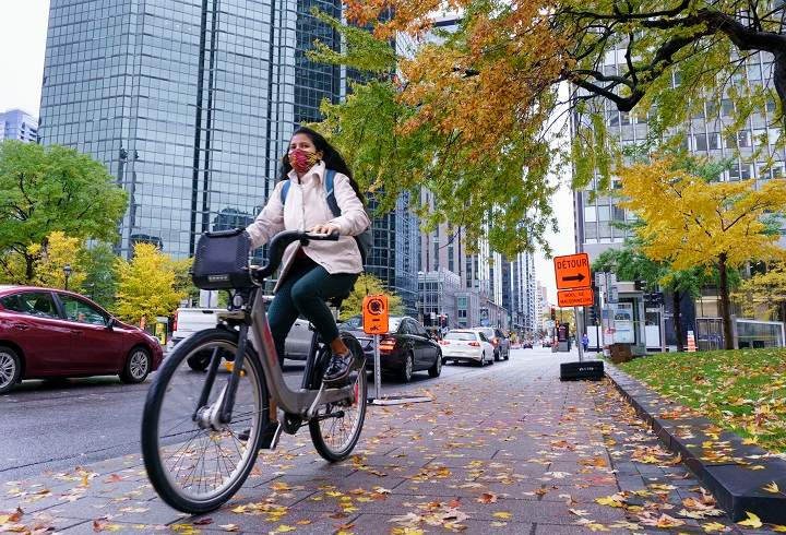 A woman rides a bike on a city street.