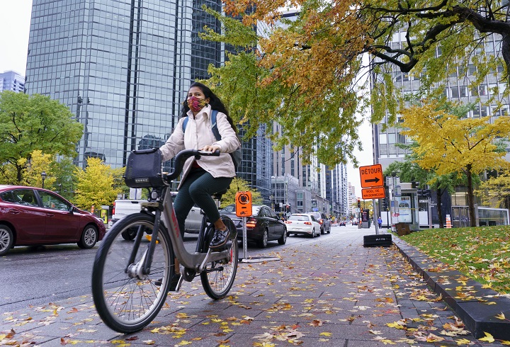 A woman rides a bike on a city street.