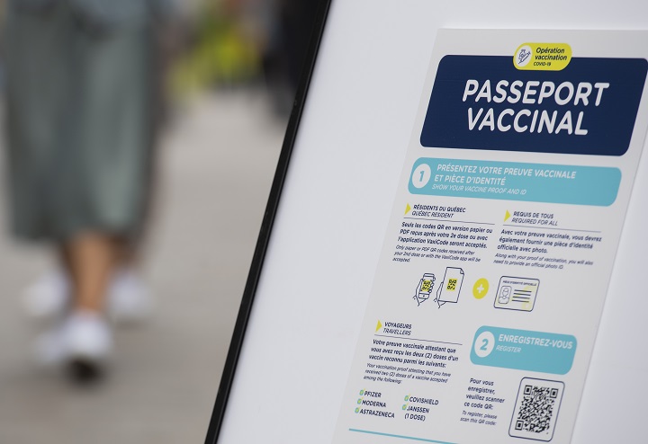 People walk by a sign outside a restaurant advising customers of the Quebec government's newly implemented Covid-19 vaccine passport in Montreal, Monday, September 6, 2021, as the COVID-19 pandemic continues in Canada and around the world. 