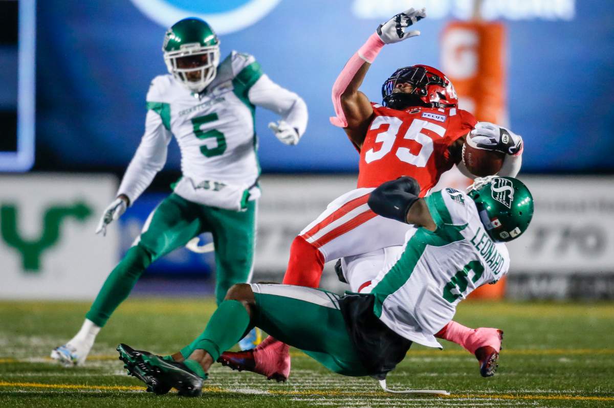 Saskatchewan Roughriders' A.C. Leonard, right, brings down Calgary Stampeders' Ka'Deem Carey in Calgary on Oct. 23, 2021.
