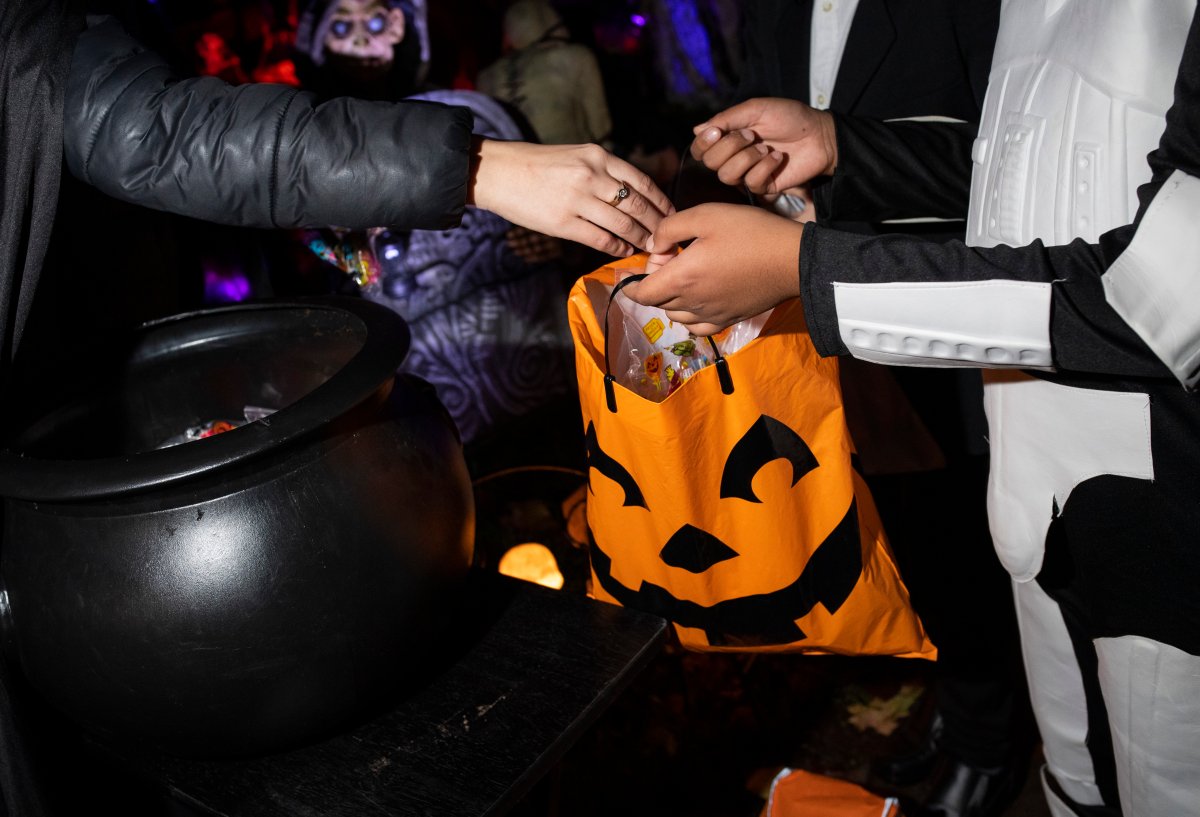 A trick-or-treater gets a bag of candy on Halloween night in Ottawa, on Sunday, Oct. 31, 2021. 