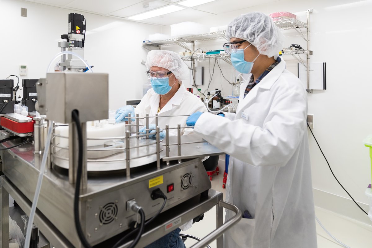 Dr. Raimar Lobenberg, director of Applied Pharmaceutical Innovation and University of Alberta professor, works with researcher Chulhun Park on an automated filling machine in a cleanroom used for clinical trial production in an undated handout photo.