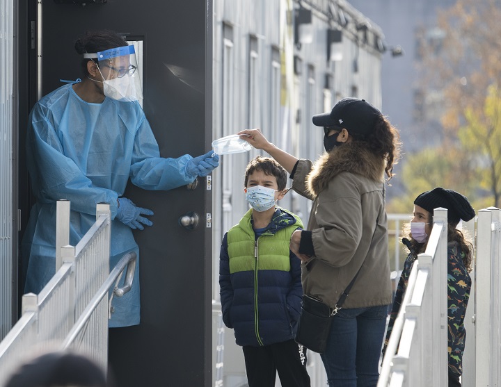 A healthcare worker hands out facemasks at a COVID-19 testing clinic Tuesday, November 9, 2021  in Montreal. 