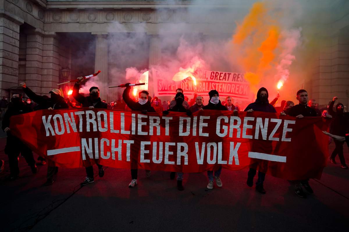 Demonstrators shout slogans and light flares during a demonstration against measures to battle the coronavirus pandemic in Vienna, Austria, Saturday, Nov. 20, 2021.