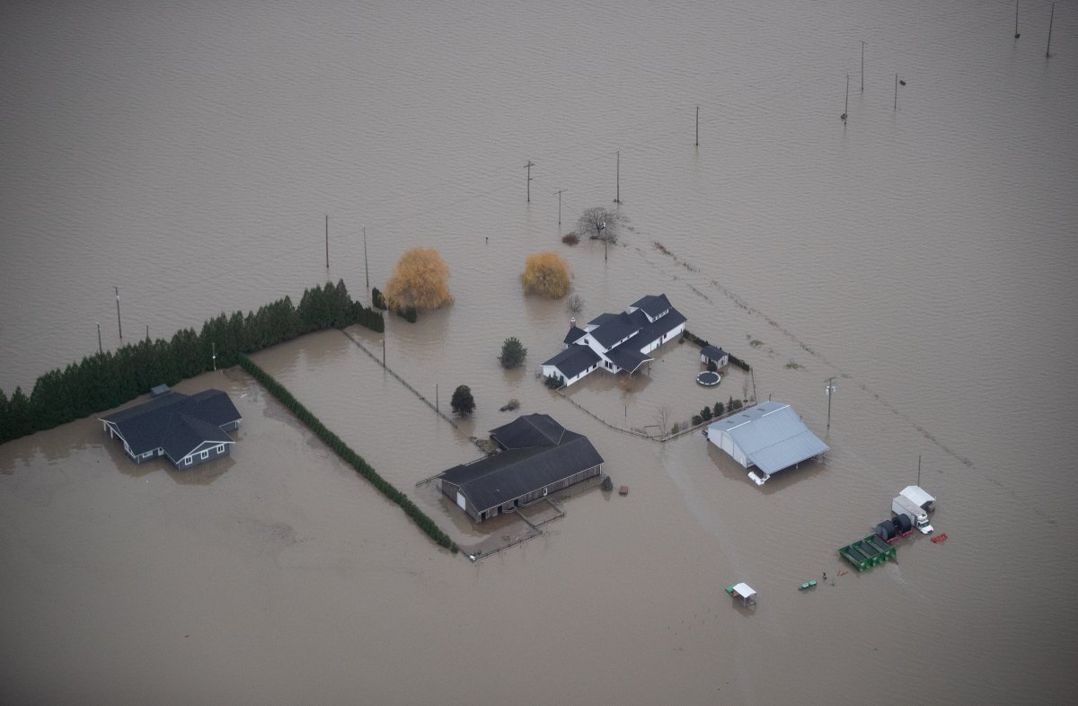 Houses and barns are surrounded by floodwaters on a farm in Abbotsford, B.C., on Monday, November 22, 2021. 