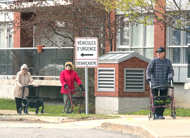 Seniors walk in front of their residence Tuesday May 5, 2020  in Montreal. 