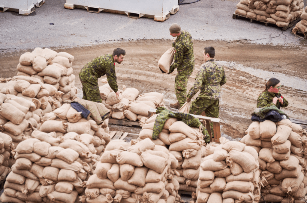 Members of the Canadian Armed Forces use sandbags to protect a critical pump station in Abbotsford, B.C. after the city was flooded by torrential downpour between Nov. 14 and 15, 2021.