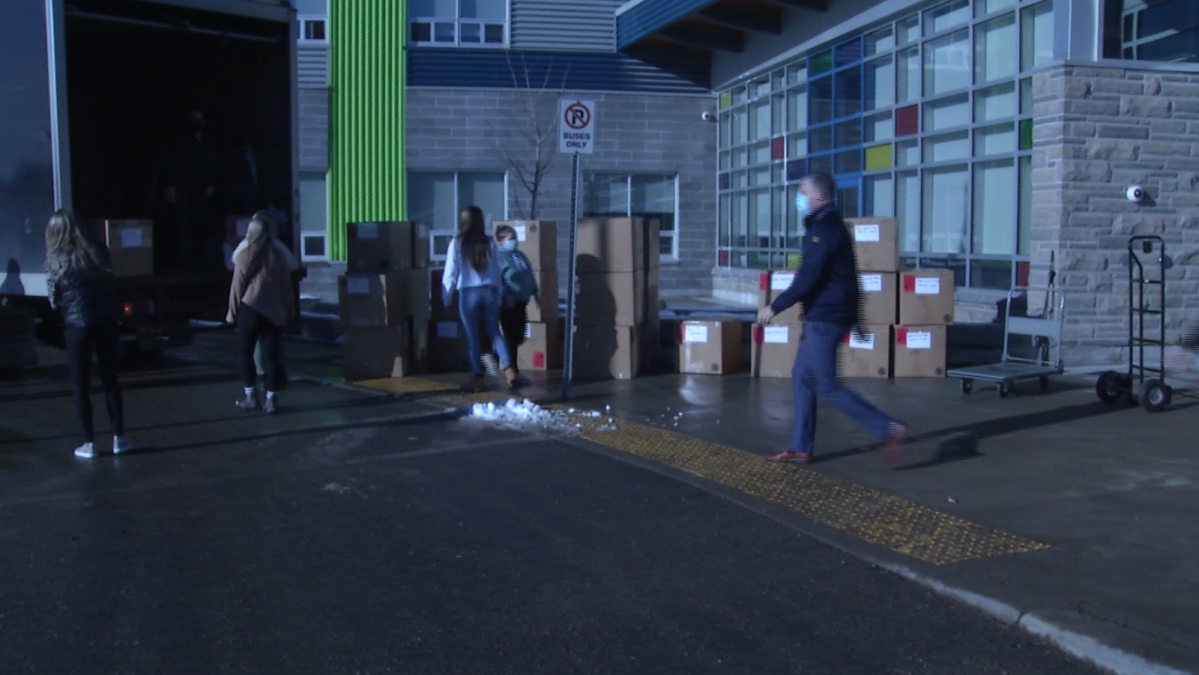 Volunteers help unload boxes of winter jackets donated to Corus Kingston's Clothes for Kids.