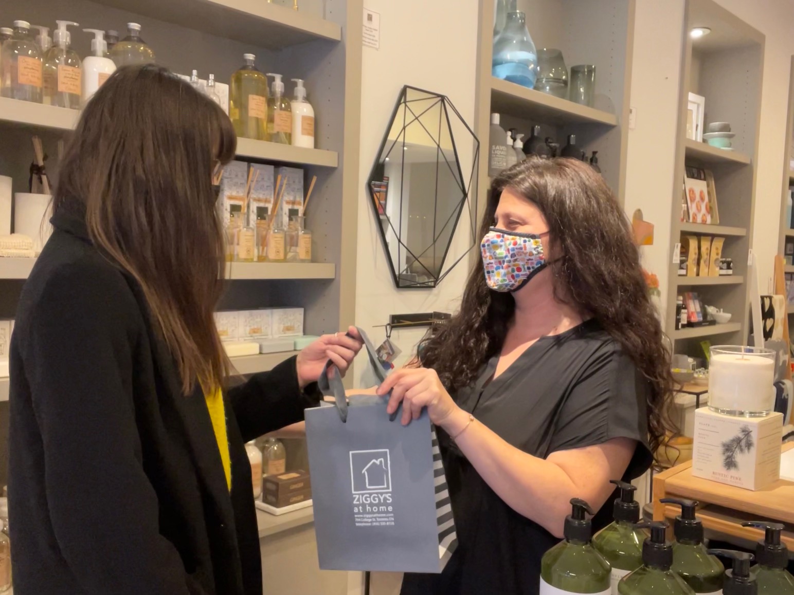 Julie Fass passes gift bag to customer