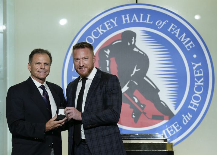 Mike Gartner, left, gives a ring to Hockey Hall of Fame inductee Marian Hossa in Toronto, Friday, Nov. 12, 2021.